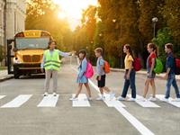 Shutterstock_2360708957_kids cross road by crosswalk_bērni šķērso ielu pa gājēju pāreju.jpg