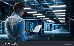 stock-photo-back-view-of-male-specialist-using-laptop-in-big-data-center-office-high-speed-data-transfer-2136788491.jpg