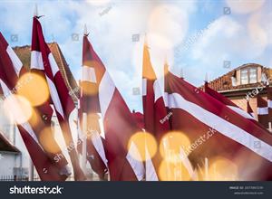 stock-photo-lots-of-latvian-red-and-white-flags-on-the-day-of-proclamation-of-the-republic-of-latvia-faded-2077847239.jpg