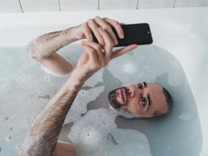 Shutterstock_2041341992_with smartphone in bath_ar telefonu vannā.jpg
