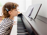 Shutterstock_2167857363_little girl playing piano_maza meitene spēlē klavieres.jpg