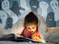 shutterstock_1944284377_girl reading spooky book_meitene lasa šausmu stāstus.jpg