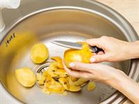 Shutterstock_2489331933_peeling potatoes_tīra kartupeļus.jpg